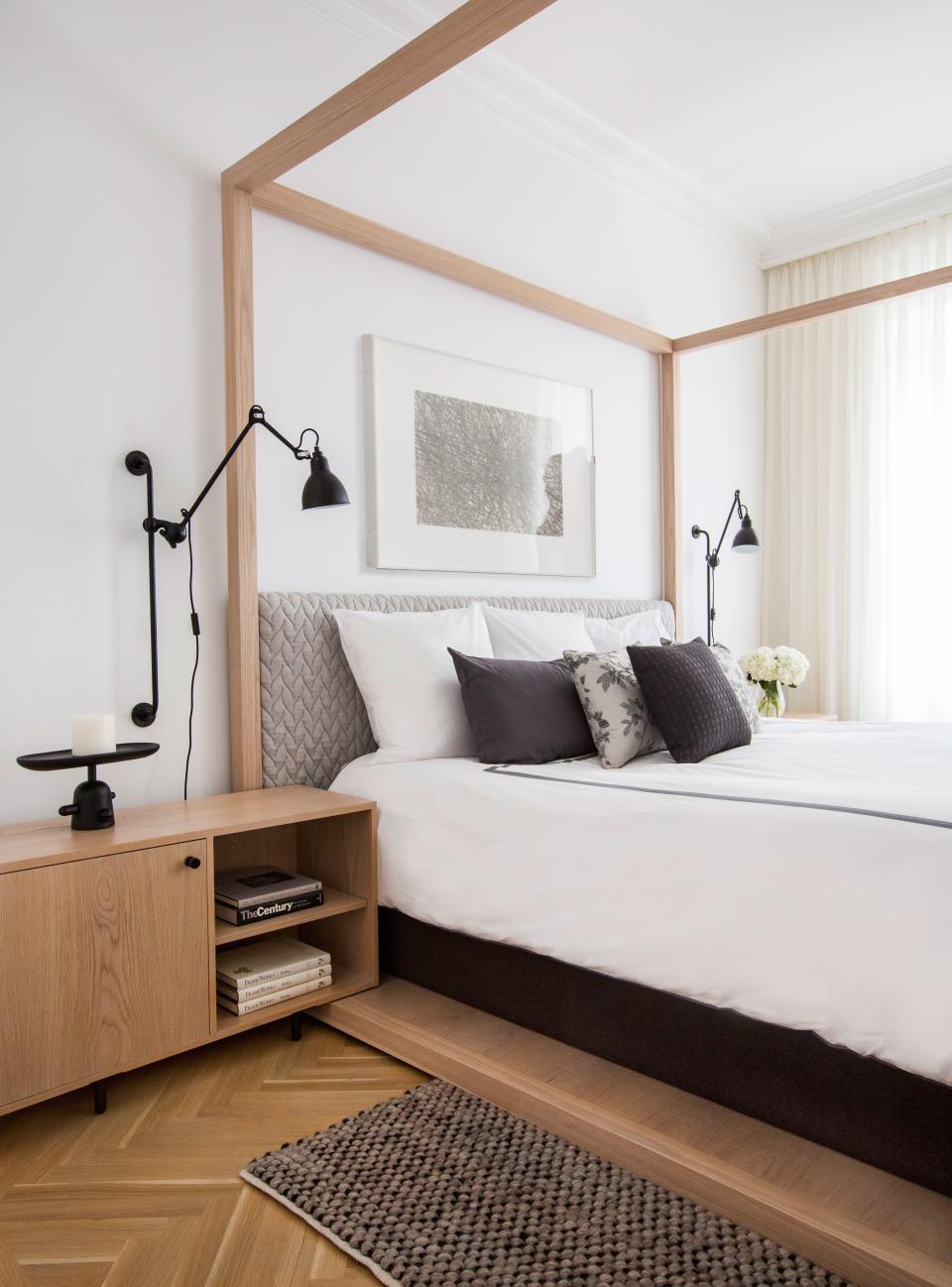 A minimalist custom-designed four-poster bed anchors the master bedroom. “It‘s really seamless woodwork inspired by Japanese traditions; there’s no hardware,” says Grehl of the piece, which was built by A.B. Hornbake (as were the matching bedside tables). The adjustable reading lamps, designed in the ’20s by Bernard-Albin Gras, are from Design Within Reach. To add coziness, Grehl picked an upholstered headboard covered in Patricia Urquiola’s “Big Braid” fabric, and a textured wool carpet from Bludot.