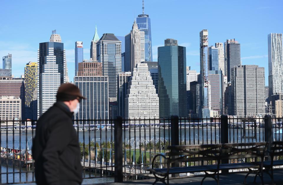 A man wearing a face mask takes a walk on the Brooklyn Heights Promenade on March 24, 2020 in New York. - US lawmakers closed in on a deal Tuesday to help save the teetering economy by injecting nearly $2 trillion into pockets of struggling Americans, devastated businesses and hospitals struggling to contain the coronavirus pandemic. (Photo by Angela Weiss / AFP) (Photo by ANGELA WEISS/AFP via Getty Images)