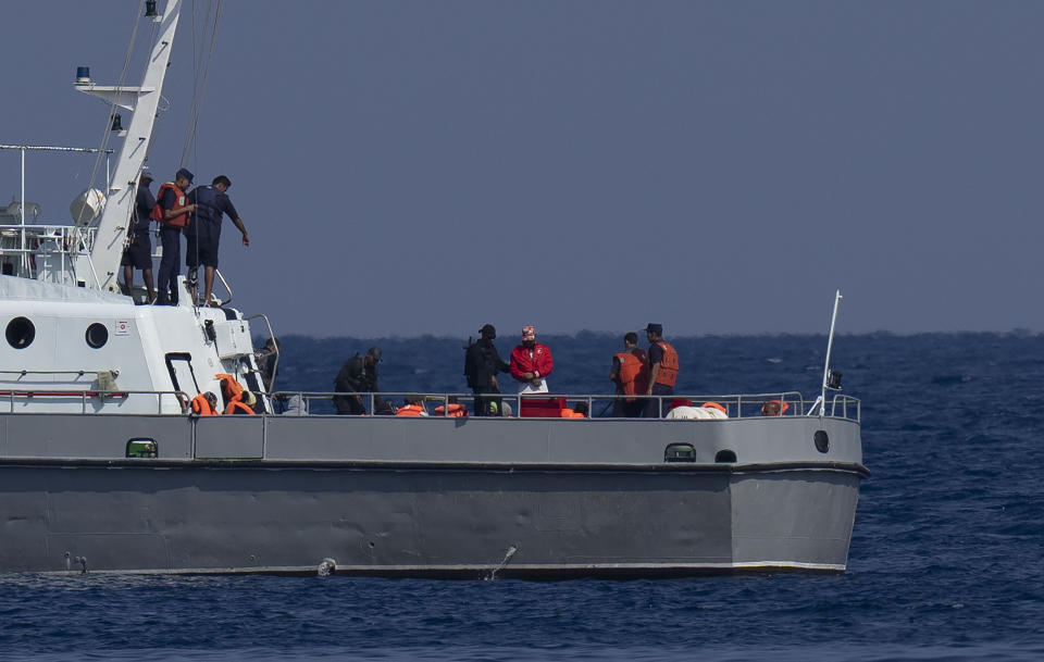 People traveling in a makeshift boat with the U.S. flag painted on the side ride in a Cuba Coast Guard boat after being captured, near the Malecon seawall in Havana, Cuba, Monday, Dec. 12, 2022. (AP Photo/Ramon Espinosa)