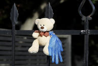 In this Tuesday, March 31, 2020 photo, a teddy bear hangs on a fence outside a house in Christchurch, New Zealand. New Zealanders are embracing an international movement in which people are placing teddy bears in their windows during coronavirus lockdowns to brighten the mood and give children a game to play by spotting the bears in their neighborhoods. (AP Photo/Mark Baker)