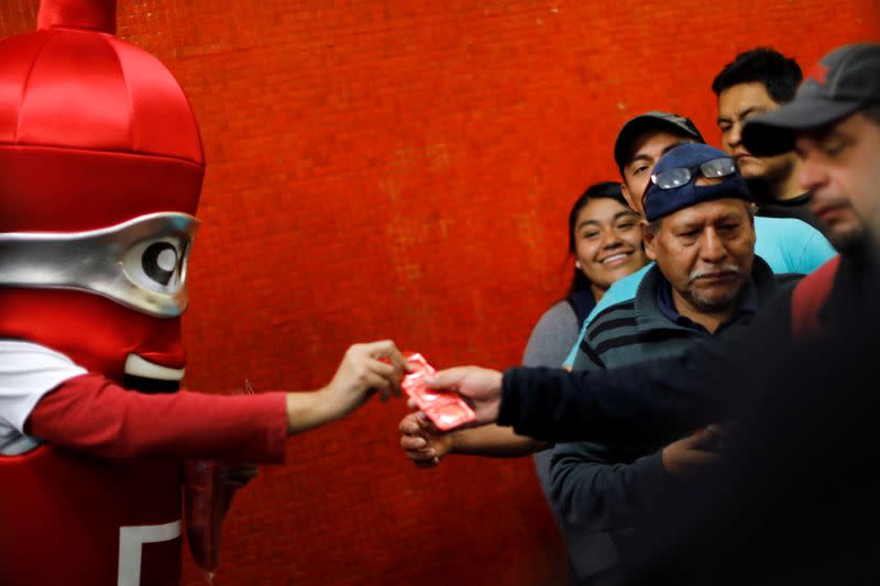 A man wearing a condom costume gives out free condoms inside the metro on International Condoms Day, celebrated a day before Valentine Day, in Mexico City