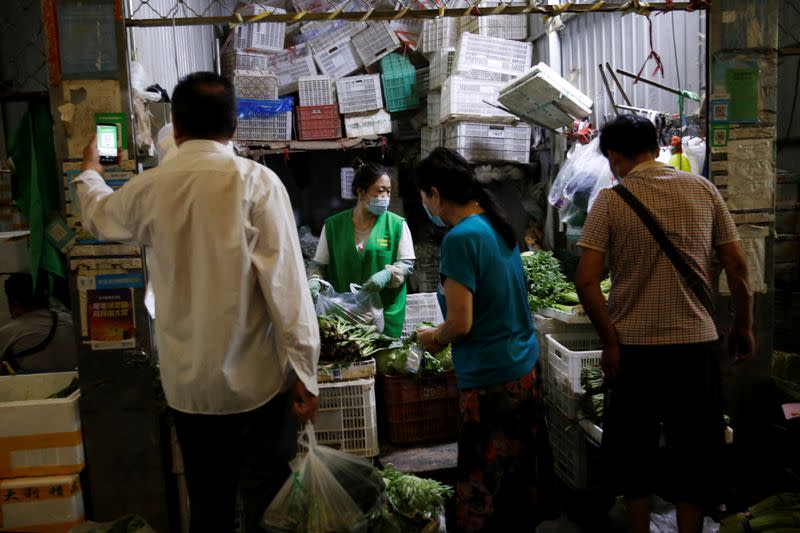 Customer scans a QR code to pay for vegetables inside the Yuegezhuang wholesale market, following new cases of coronavirus disease (COVID-19) infections in Beijing