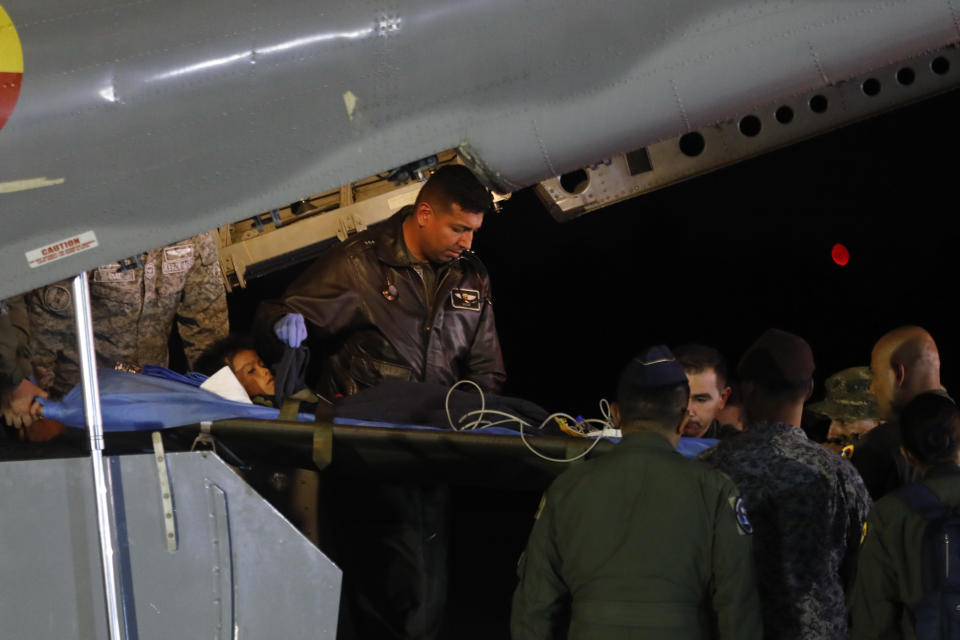 Military personnel unload from a plane one of four Indigenous children who were missing after a deadly plane crash at the military air base in Bogota, Colombia, Saturday, June 10, 2023. The children survived a small plane crash 40 days ago and had been the subject of an intense search in the jungle. (AP Photo/John Vizcaino)