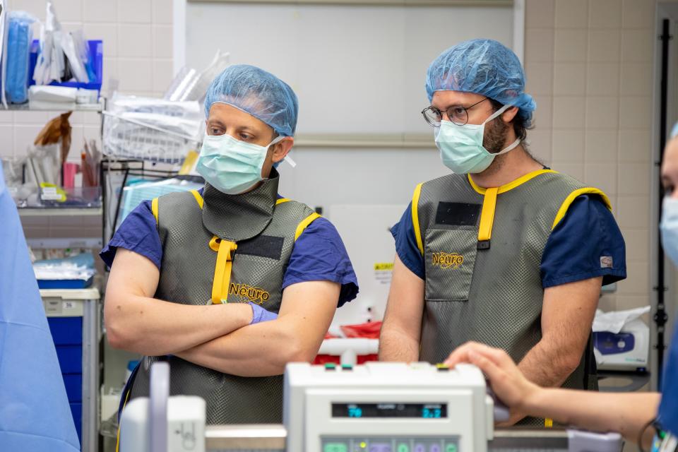 Lee Fisher, left, and Marco Capogrosso, observe the implantation of the spinal cord stimulation electrodes at UPMC Presbyterian hospital.