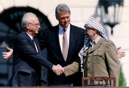 FILE PHOTO: PLO Chairman Arafat shakes hands with Israeli PM Rabin after the signing of the Israeli-PLO peace accord, in Washington