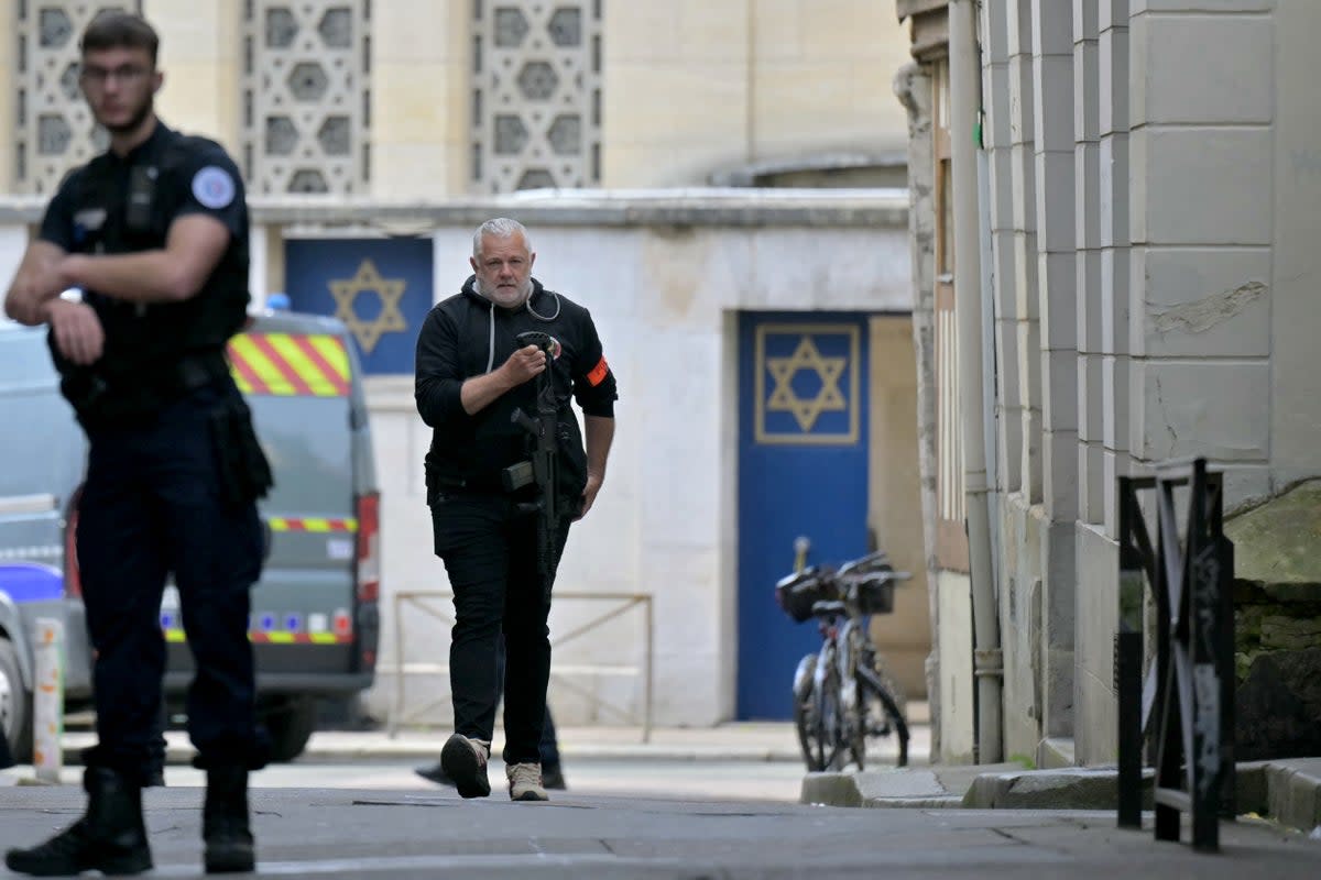 A police officer holds a riffle as he walks by an entrance of a synagogue in the Normandy city of Rouen where French police have killed earlier an armed man who was trying to set fire to the building (AFP via Getty Images)