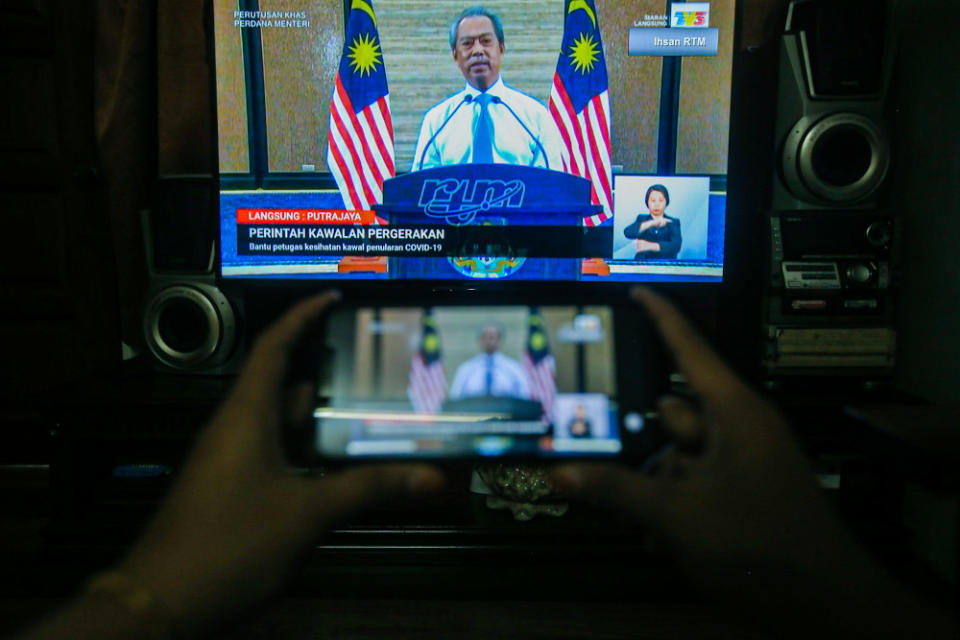 People watch the live telecast of the Prime Minister Tan Sri Muhyiddin Yassin announcing the extension of the movement control order due to the Covid-19 pandemic in Kuala Lumpur April 10, 2020. — Picture by Hari Anggara