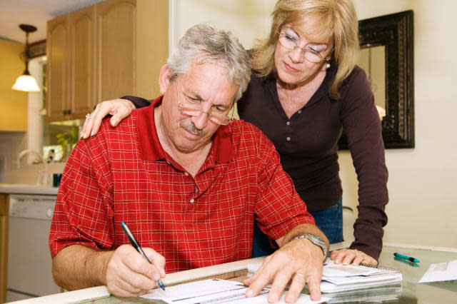 Mature couple in financial trouble is filling out a loan application