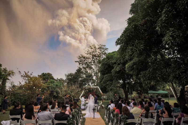 Social media image of people attending a wedding ceremony as Taal Volcano sends out a column of ash in the background in Alfonso, Cavite, Philippines