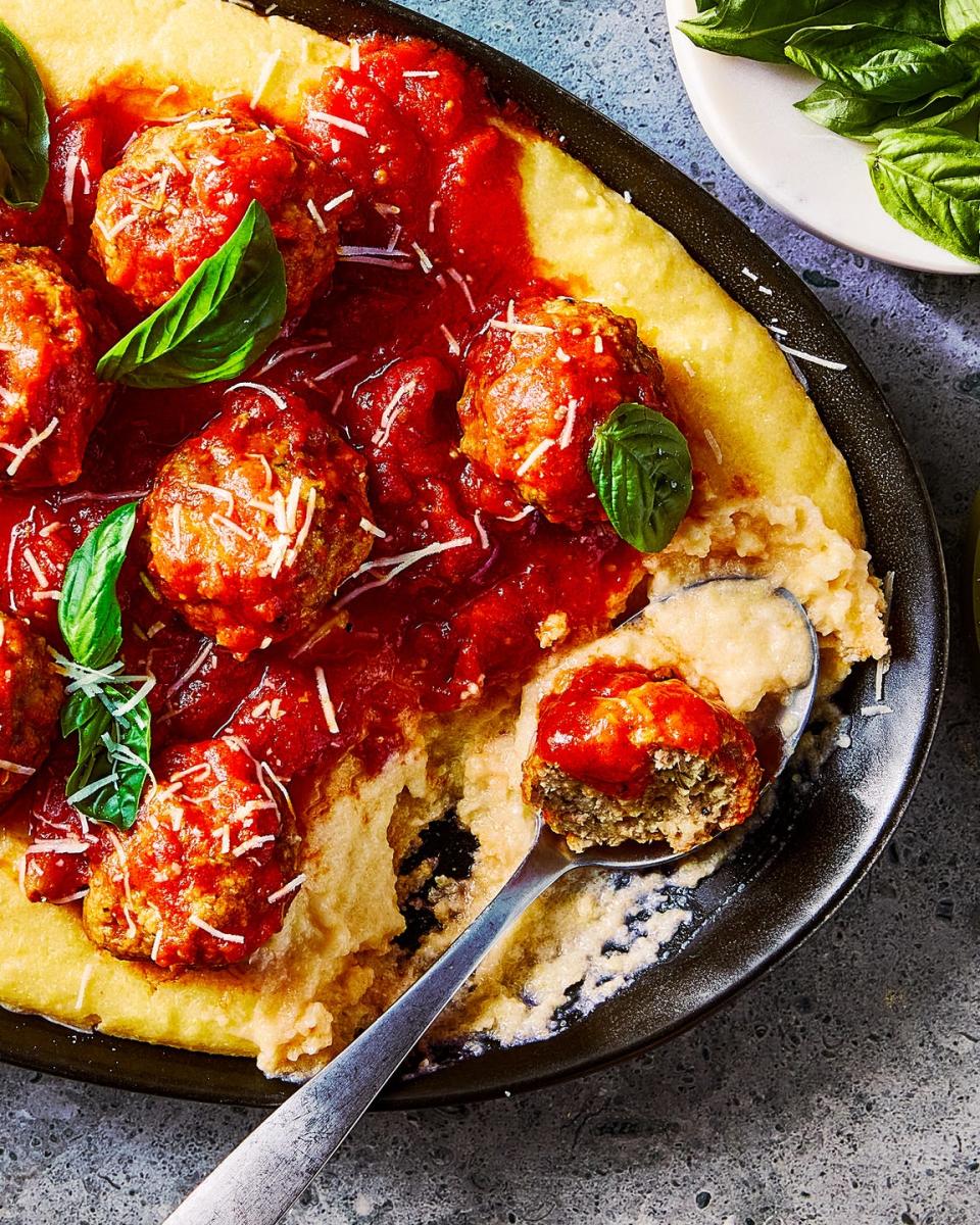 creamy polenta topped with meatballs in a red sauce