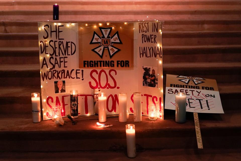 Candles are placed around signs to honor cinematographer Halyna Hutchins during a candlelight vigil in Albuquerque, N.M., Saturday, Oct. 23.