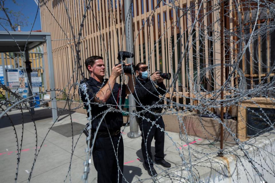 U.S. Customs and Border Protection officers take photos of Ukrainian refugees as they await to be allowed to enter the U.S. by Customs and Border Protection at the San Ysidro Port of Entry in Tijuana, Baja California on Tuesday.