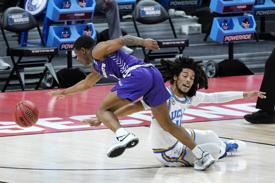 Abilene Christian's Damien Daniels, left, and UCLA's Tyger Campbell, right, battle for a loose ball during the first half of a college basketball game in the second round of the NCAA tournament at Bankers Life Fieldhouse in Indianapolis Monday, March 22, 2021. (AP Photo/Mark Humphrey)