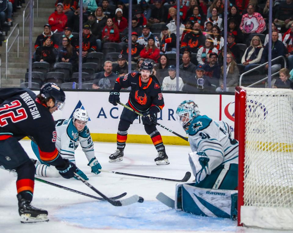 Coachella Valley forward Marian Studenic (34) fires a pass to forward Tucker Robertson (32) to try to tip in a quick goal that ends up blocked by San Jose goaltender Georgi Romanov (31) during the first period of their game at Acrisure Arena in Palm Desert, Calif., Thursday, April 4, 2024.