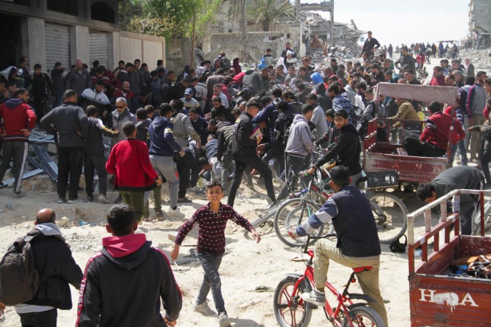 Palestinians rush to get humanitarian aid dropped by the US Air Force into Gaza City (AP)