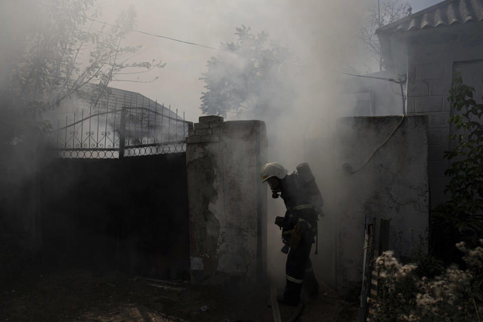 A rescue worker puts out the fire at the house destroyed by a Russian attack in Mykolaiv, Ukraine, Friday, Aug. 5, 2022. (AP Photo/Evgeniy Maloletka)