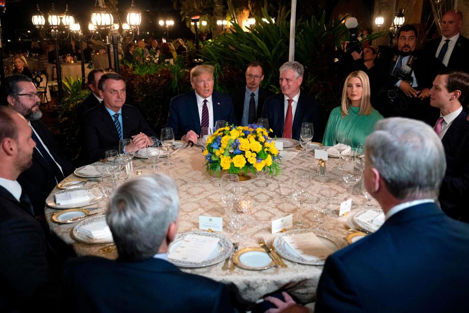 President Donald Trump speaks with Brazilian President Jair Bolsonaro (L) during a dinner at Mar-a-Lago in Palm Beach, Fla., on March 7, 2020.