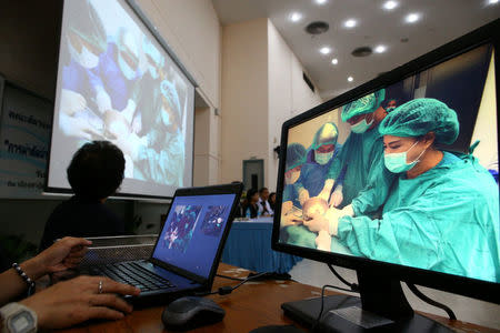 Screen show Thai veterinarians operate Omsin, a 25 year old femal green sea turtle, during a surgical operation to remove coins from her stomach, during a news conference at the Faculty of Veterinary Science, Chulalongkorn University in Bangkok, Thailand March 6, 2017. REUTERS/Athit Perawongmetha