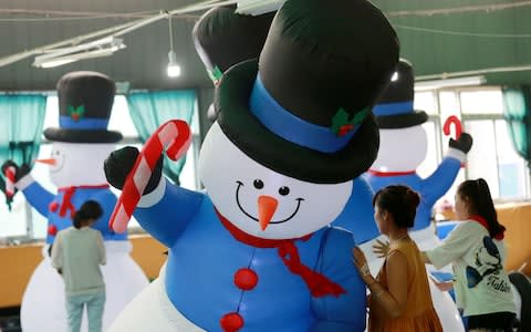 Workers checking inflatable snowmen made for export at a factory in Huaibei in China's eastern Anhui province - Credit: AFP