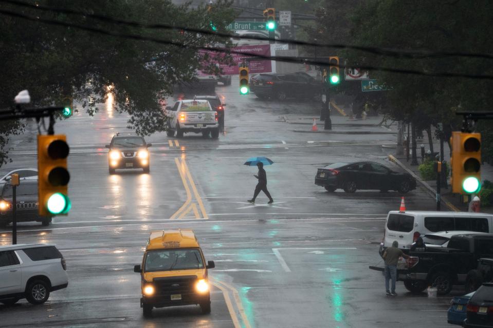 A pedestrian uses an umbrella to shield themself from the rain as they cross Palisades Ave in Englewood, NJ on Monday Sept. 25, 2023.