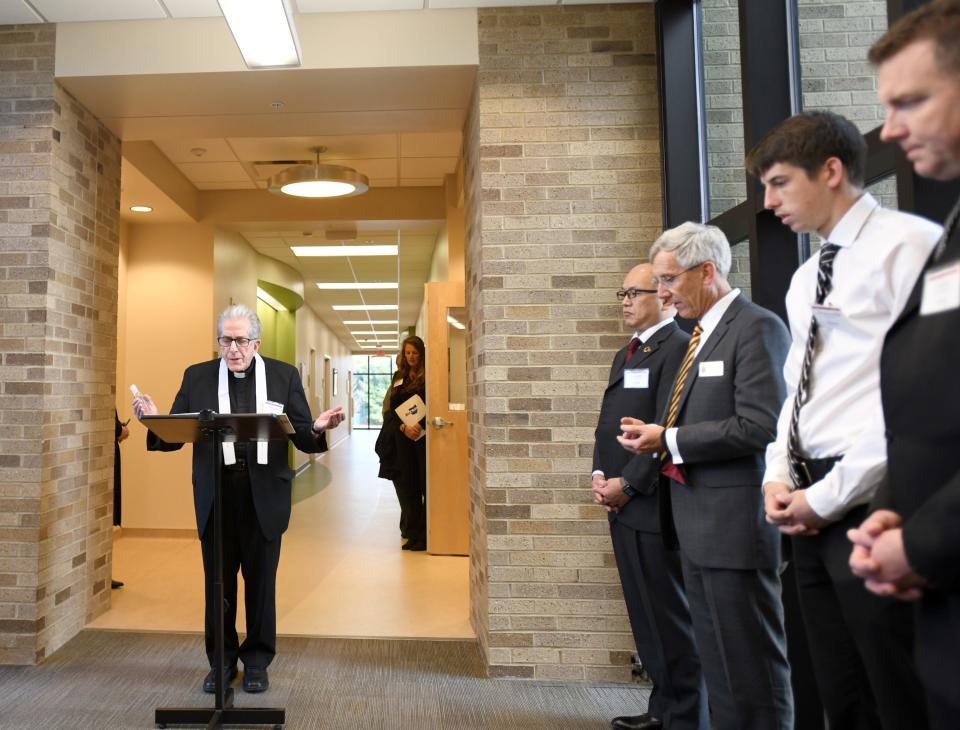 Father Thomas Cebula, senior chaplain with Walsh University, delivers a blessing Tuesday during dedication services for the university's SPARQ Analytical Laboratory of Scientific Excellence.