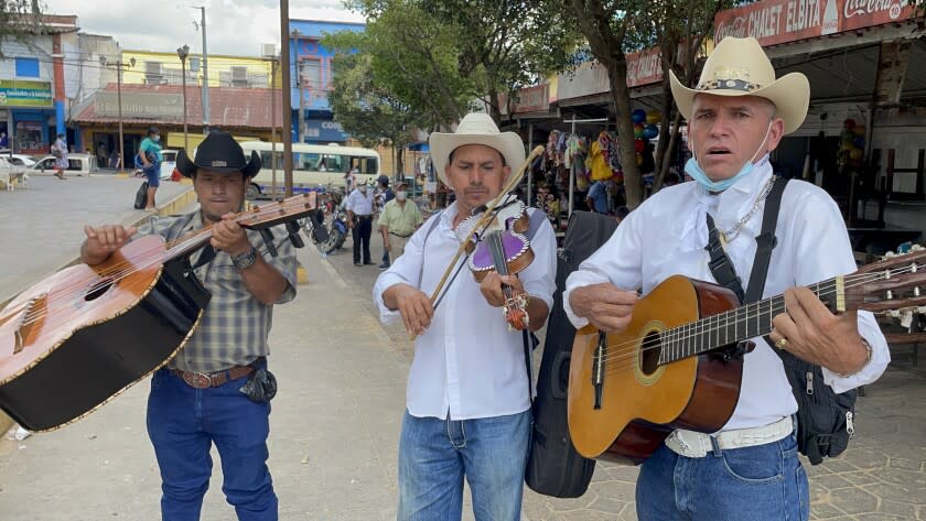 Roving musicians offer their services in the central park of Sensuntepeque, Cabanas, in search of Salvadorans visiting from the United States.