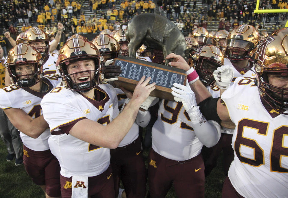 IOWA CITY, IOWA - OCTOBER 21: Quarterback Athan Kaliakmanis #8 of the Minnesota Golden Gophers celebrates with teammates as they hold the Floyd of Rosedale Trophy following their matchup against the Iowa Hawkeyes at Kinnick Stadium on October 21, 2023 in Iowa City, Iowa. (Photo by Matthew Holst/Getty Images)