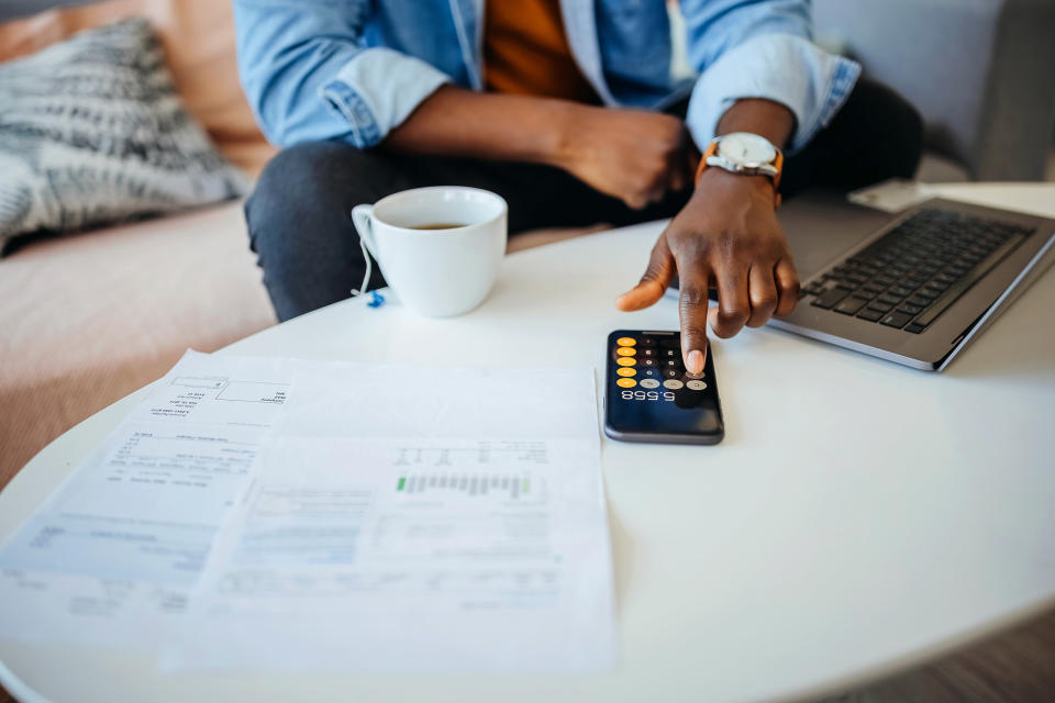 Person looking at loan documents and using a calculator