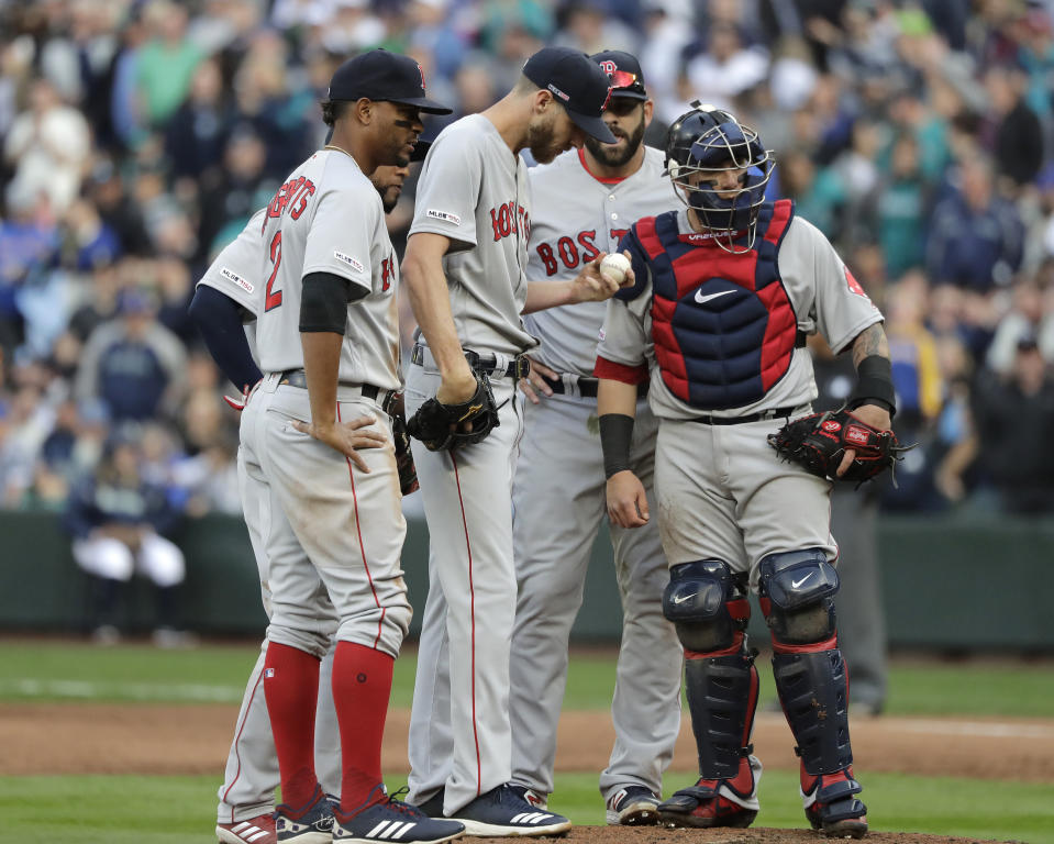 Boston Red Sox starting pitcher Chris Sale holds the ball during a mound conference in the third inning of the team's baseball game against the Seattle Mariners, Thursday, March 28, 2019, in Seattle. Sale was pulled from the game after the inning. (AP Photo/Ted S. Warren)