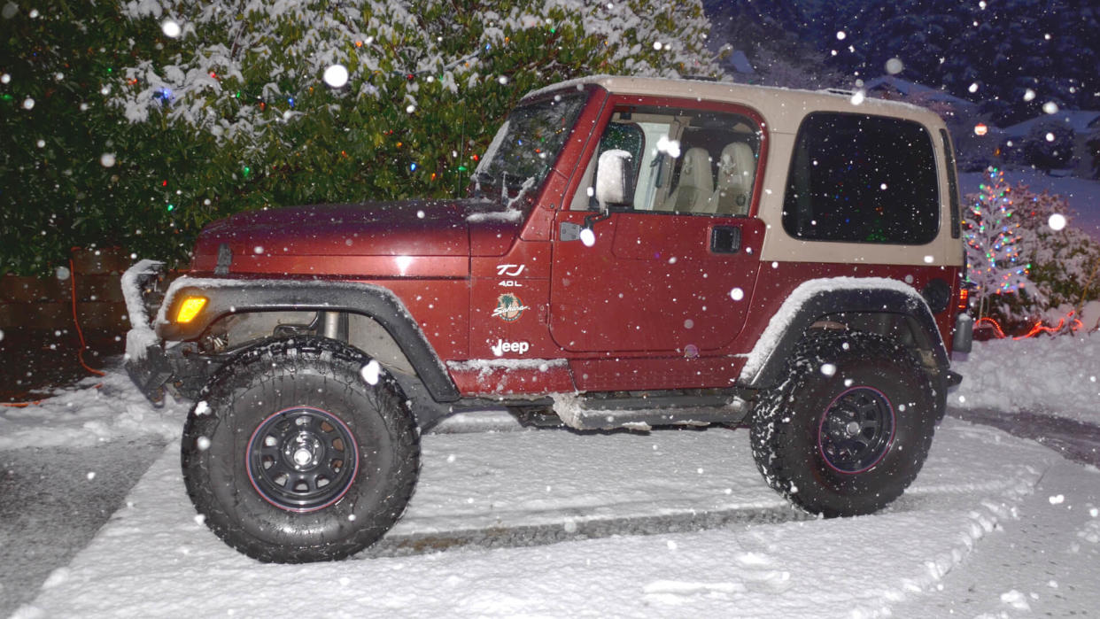 Comox, BC Canada Dec, 2017 Jeep Wrangler TJ 2001 evening photo with snow dropping and background of some Christmas lights.