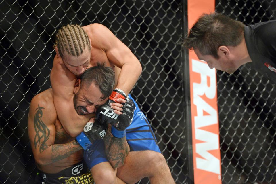 Dec 6, 2014; Las Vegas, NV, USA; Urijah Faber (red) submits Francisco Rivera (blue) during UFC 181 at Madalay Bay Events Center. Faber won via second round submission. (Joe Camporeale-USA TODAY Sports)