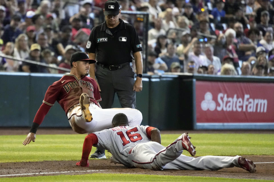 Washington Nationals' Victor Robles (16) is tagged out by Arizona Diamondbacks third baseman Josh Rojas while trying to steal third base in the third inning during a baseball game, Sunday, July 24, 2022, in Phoenix. (AP Photo/Rick Scuteri)