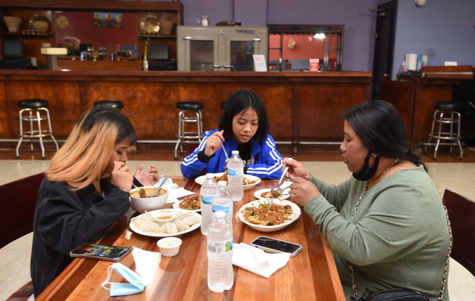 Ashika Tamang, left, Soita Magar, center, and Kalpana Rai, right, all of Erie, eat at Annapurna Kitchen, 1315 Parade St.