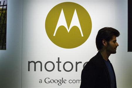 A man walks past a Motorola logo at a launch event for Motorola's new Moto X phone in New York, August 1, 2013. REUTERS/Lucas Jackson