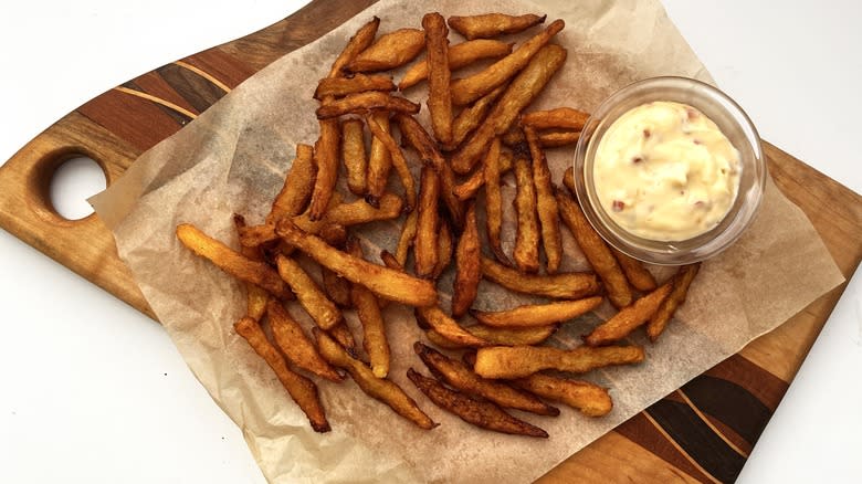 fries with mayonnaise sauce on wood serving tray