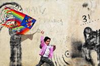 An Iranian girl runs with a kite during the ancient festival of Sizdeh Bedar, an annual public picnic day on the 13th day of the Iranian new year, at Pardisan Park, in Tehran, Iran, Wednesday, April 2, 2014. Sizdeh Bedar, which comes from the Farsi words for “thirteen” and “day out,” is a legacy from Iran’s pre-Islamic past that hard-liners in the Islamic Republic never managed to erase from calendars. Many say it’s bad luck to stay indoors for the holiday. (AP Photo/Ebrahim Noroozi)