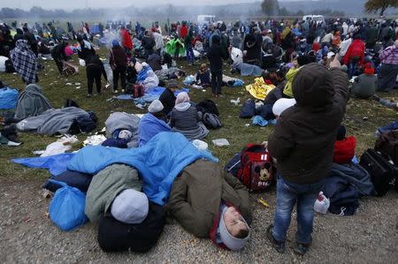 Migrants rest after crossing the border from Croatia in Rigonce, Slovenia, October 22, 2015. REUTERS/Srdjan Zivulovic