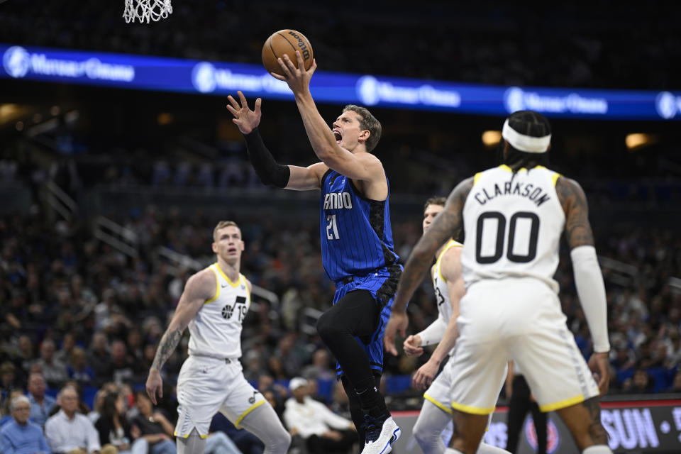 Orlando Magic center Moritz Wagner (21) goes up to shoot as Utah Jazz forward Luka Samanic (19), forward Lauri Markkanen, second from right, and guard Jordan Clarkson (00) look on during the first half of an NBA basketball game, Thursday, Feb. 29, 2024, in Orlando, Fla. (AP Photo/Phelan M. Ebenhack)