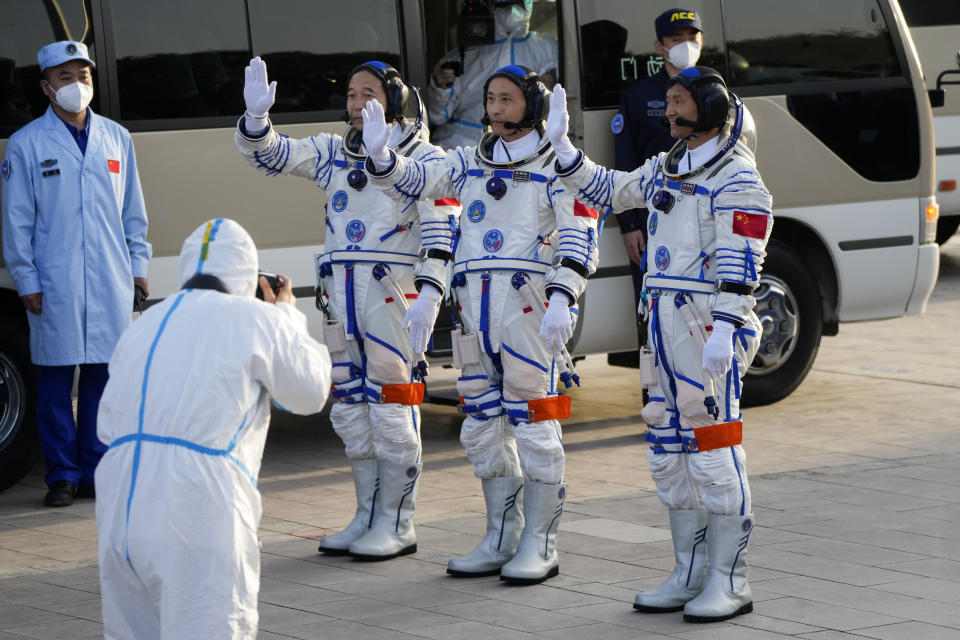 Chinese astronauts for the Shenzhou-16 mission, from left, Jing Haipeng, Zhu Yangzhu and Gui Haichao wave as they prepare to board for liftoff for their manned space mission at the Jiuquan Satellite Launch Center in northwestern China, Tuesday, May 30, 2023. (AP Photo/Mark Schiefelbein)