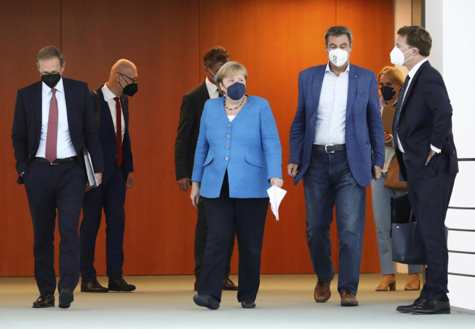 German Chancellor Angela Merkel, centre, arrives for a news conference following talks with state leaders to discuss anti-coronavirus measures at the Chancellery in Berlin, Germany, Tuesday Aug. 10, 2021. (Christian Mang/Pool via AP)