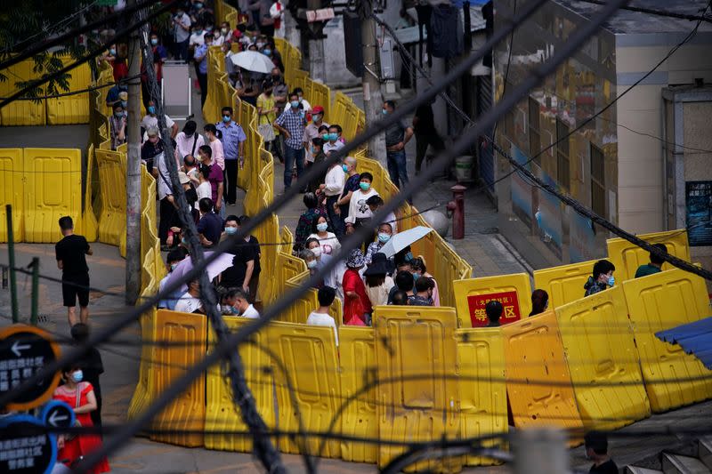 Residents wearing face masks line up for nucleic acid testings at a residential compound in Wuhan