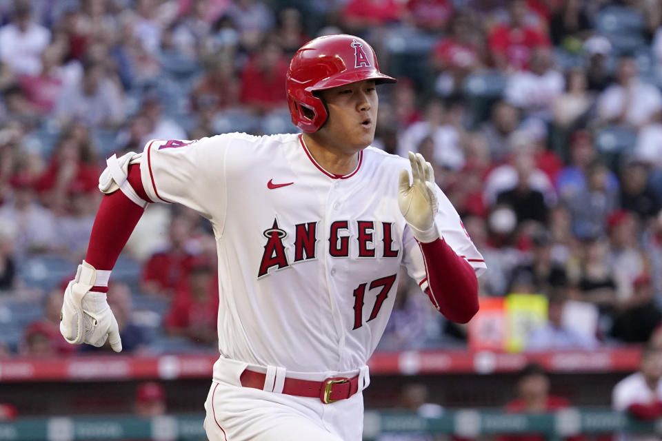 Los Angeles Angels' Shohei Ohtani, right, runs to first before being thrown out during the first inning of a baseball game against the Texas Rangers Friday, July 29, 2022, in Anaheim, Calif. (AP Photo/Mark J. Terrill)