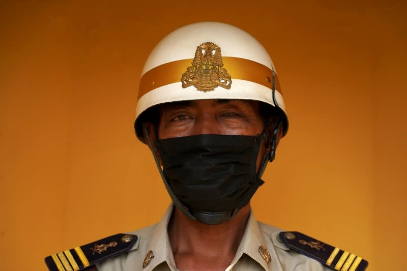 A guard outside the Royal Palace wears a protective mask as precaution against the coronavirus outbreak in Phnom Penh, Cambodia