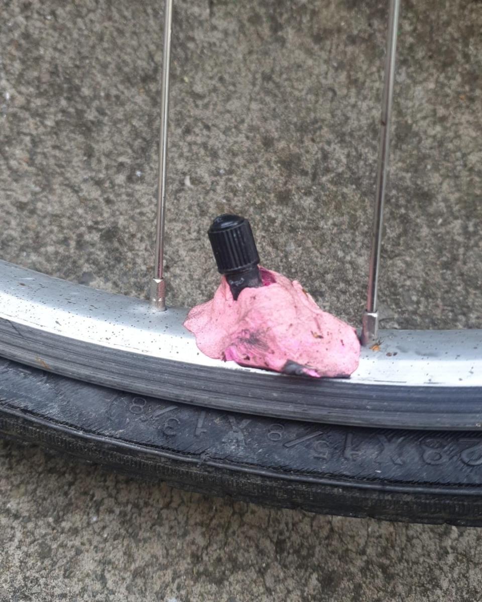 Bicycle tire with punctured pink bubble gum stuck on its valve