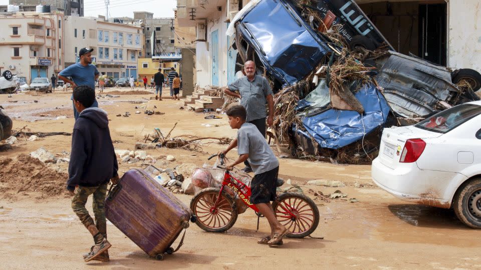 A boy pulls a suitcase past debris in a flash-flood damaged area in Derna, eastern Libya, on September 11, 2023.  - AFP/Getty Images