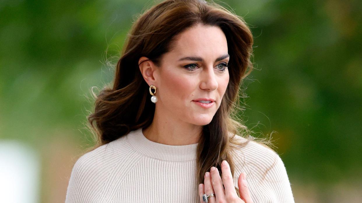 Kate Middleton in a white top wearing her engagement ring