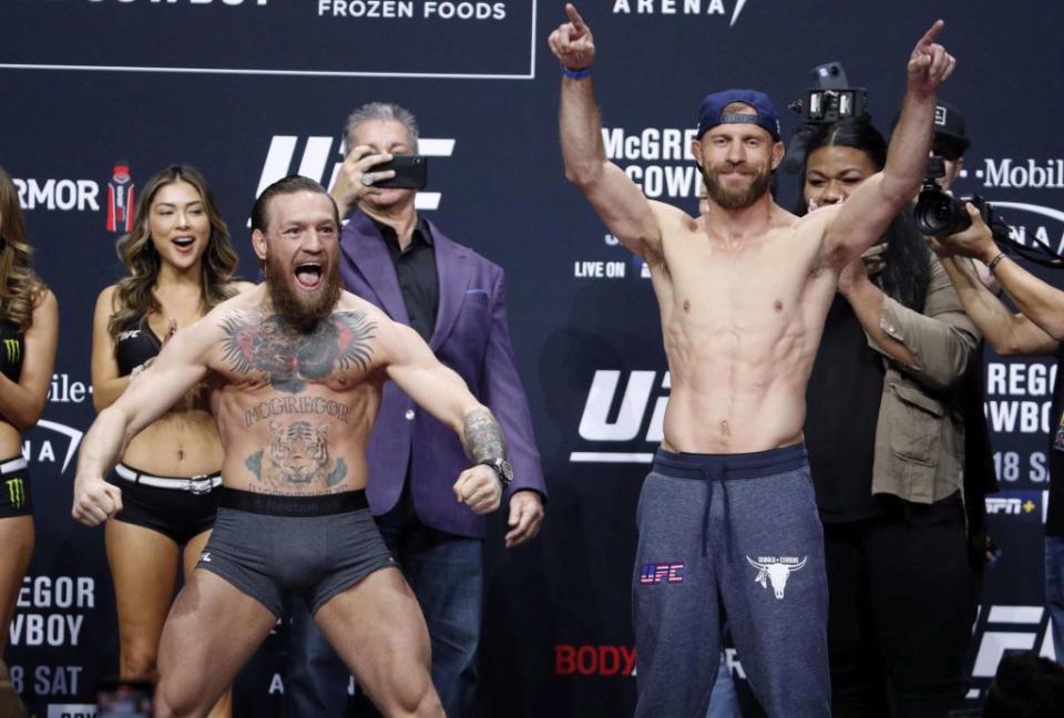 UFC拳手麥葛雷格(左)與賽隆尼在過磅儀式展現肌肉。（美聯社資料照）