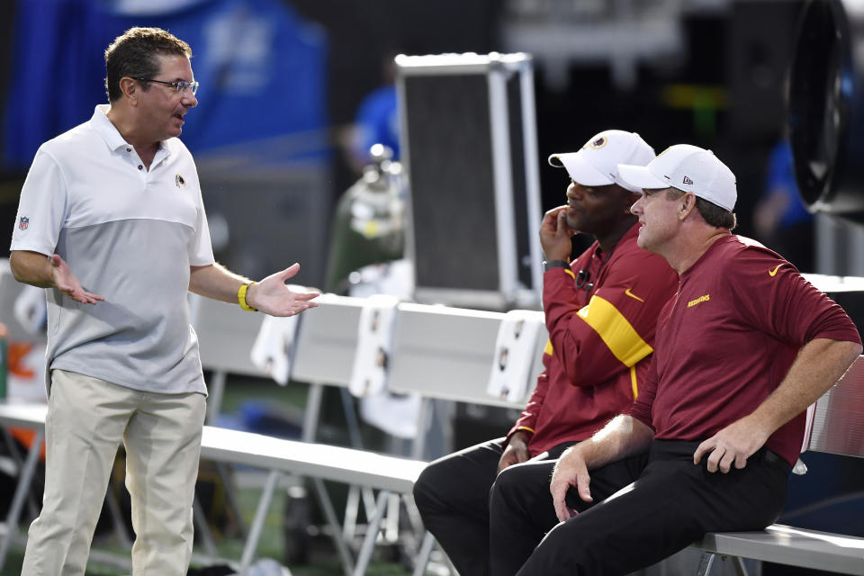 Washington Redskins owner Daniel Snyder, left, speaks with Washington Redskins head coach Jay Gruden, right, before the first half an NFL preseason football game against the Atlanta Falcons, Thursday, Aug. 22, 2019, in Atlanta. (AP Photo/Mike Stewart)