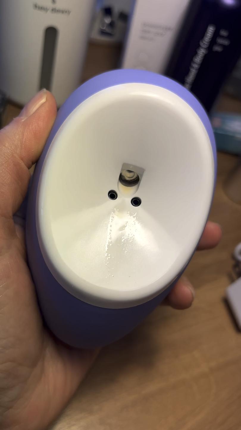purple droplette skincare device being held in someone's hand