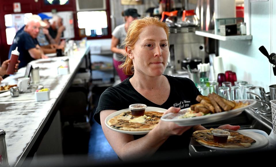 Waitress Vanessa Muccio carries an armful of breakfasts for early-morning customers at Chet's Diner in Northborough, July 13, 2022.